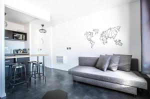 a living room with a couch and a kitchen at DISNEYLAND PARIS NEW STUDIO SUITE DESIGN in Bailly-Romainvilliers