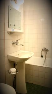 a bathroom with a sink and a bath tub at Hotel Tivoli in Sovata