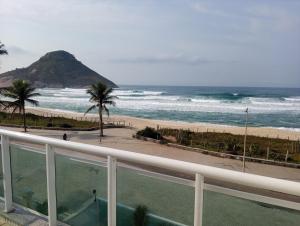 un apartamento en condominio con vistas a la playa desde el balcón en Reserva Pontal, en Río de Janeiro