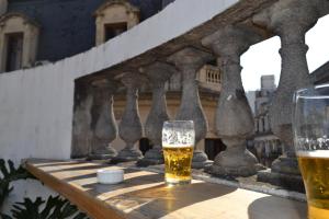a glass of beer sitting on a table on a balcony at Che Argentina Hostel Suites in Buenos Aires