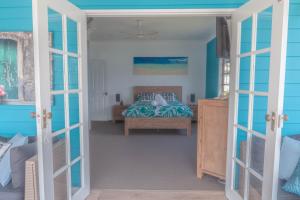 - une chambre avec un lit et un mur bleu dans l'établissement The Jetty House Jervis Bay, à Myola
