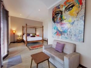 a living room with a painting of a woman at Artoria Dream Villas Bali in Nusa Dua