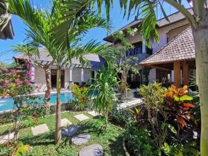 a house with a garden and a swimming pool at Artoria Dream Villas Bali in Nusa Dua