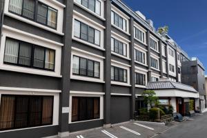a large gray building with windows on a street at Ishicho in Kyoto