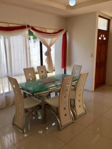 comedor con mesa de cristal y sillas en Casa Playa Bahia Ballena de Osa, en Uvita