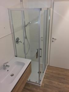 un bagno con doccia e lavandino bianco di New fegina a Monterosso al Mare Altre 15 foto