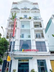 un grand bâtiment blanc avec un panneau sur celui-ci dans l'établissement Linh Phuong 5 Hotel, à Cần Thơ