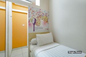 a small room with a bed and a wall with a map at Tamansari Agung Residence in Jakarta