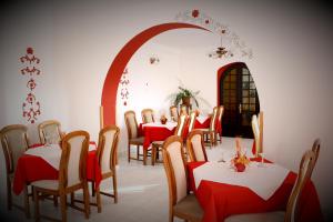 a dining room with red and white tables and chairs at Hotel Tivoli in Sovata