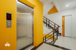 een lift in een gebouw met gele muren en trappen bij Tamansari Agung Residence in Jakarta