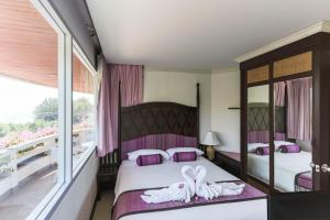 a bedroom with two beds and a balcony at Methavalai Hotel in Cha Am