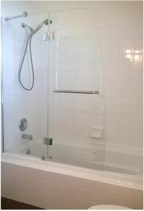 um chuveiro com uma porta de vidro na casa de banho em The Blue Inn Family Vacation Rental em Smiths Point Settlement