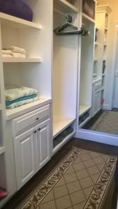 a walkin closet with white cabinets and a door open at The Blue Inn Family Vacation Rental in Smith Point