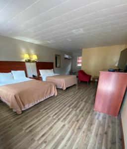 a hotel room with two beds and a flat screen tv at Motel Reedsburg in Reedsburg