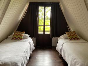 two beds in a room with a window at Villa Calas in Vara Blanca