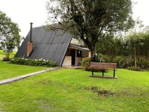 un banc assis dans l'herbe devant une maison dans l'établissement Villa Calas, à Vara Blanca