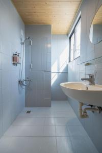 a white bathroom with a sink and a shower at September I 國華街住宿 in Tainan