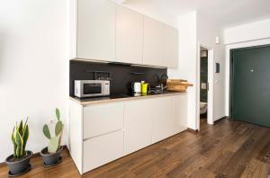 a kitchen with white cabinets and a microwave at Athens' Best Location- Stunning & Spacious Studio in Athens