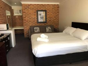 a hotel room with a bed and a tv at Lake Macquarie Motor Inn in Belmont