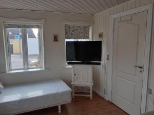 a bedroom with a flat screen tv on a wall at Belvedere B&B in Svendborg