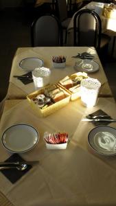 una mesa con platos, utensilios y comida. en Albergo Residence Isotta, en Veruno