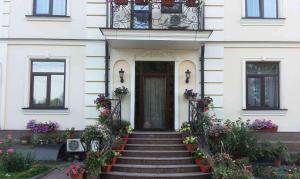 una casa bianca con scale che conducono a una porta di VLG Hotel a Boryspilʼ