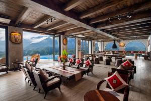 a restaurant with tables and chairs and large windows at Sapa Catcat Hills Resort & Spa in Sa Pa