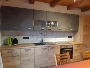 a kitchen with wooden cabinets and a sink at Ferienwohnung Örgenbauer in Saalfelden am Steinernen Meer