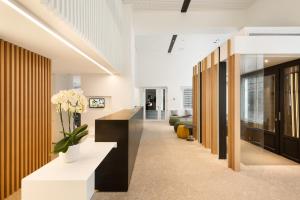 an office lobby with a reception desk and flowers at Hotel Bourgoensch Hof in Bruges