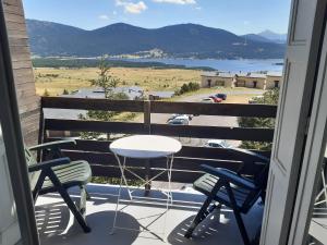 ein Tisch und zwei Stühle auf einem Balkon mit Aussicht in der Unterkunft Appt T2 & Cabine - Superbe vue - WIFI in Les Angles