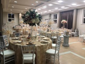 um salão de banquetes com mesas e cadeiras com flores em Teschemakers Resort em Oamaru