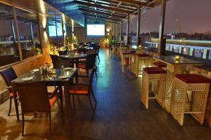 a restaurant with tables and chairs on a balcony at Comfort Inn in Lucknow