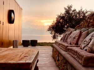 a bench with a table and a sunset in the background at Container Suite in Terrasini