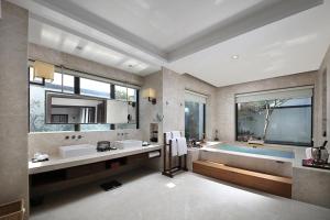 ein großes Badezimmer mit zwei Waschbecken und einer Badewanne in der Unterkunft Elite Spring Villas in Anxi