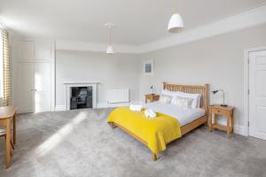 a white bedroom with a bed and a fireplace at Spacious Maisonette with Parking - 10 mins walk from Bath Abbey - 2 Bed & 2 Bath in Bath