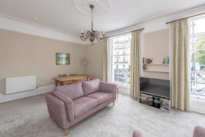 a living room with a couch and a table at Spacious Maisonette with Parking - 10 mins walk from Bath Abbey - 2 Bed & 2 Bath in Bath