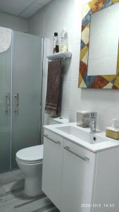 a white bathroom with a toilet and a sink at Apartamento La Luna in Lumpiaque +22 photos