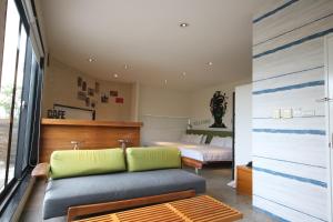 a living room with a couch and a bed at Hotel Papa Whale-Kaohsiung Formosa Boulevard in Kaohsiung