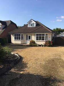 a white house with a large yard at Redcot holiday bungalow in Peover Superior