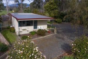 a small white house with a red roof at Karoola Cottage Self Contained in Lilydale