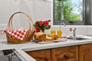 a kitchen counter with a basket of bread and a sink at Karoola Cottage Self Contained in Lilydale