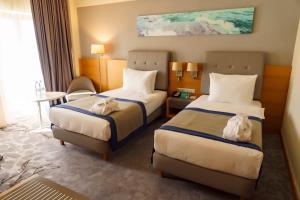 una camera d'albergo con due letti e un tavolo di Holiday Inn - Aktau - Seaside, an IHG Hotel ad Aqtau