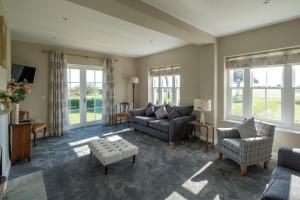 a living room with a couch and chairs and windows at The Dower House in Sizewell