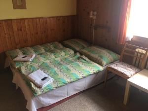1 cama con toallas y 1 silla en una habitación en Lesní Bouda en Pec pod Sněžkou