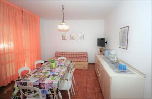 comedor con mesa y cocina en Appartamenti Las Palmas, en Lignano Sabbiadoro