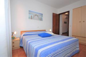 Un dormitorio con una cama con una almohada azul. en Appartamenti Las Palmas, en Lignano Sabbiadoro