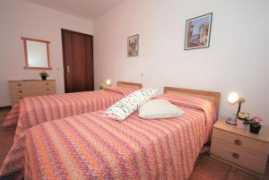 2 camas en un dormitorio con 2 almohadas en Appartamenti Las Palmas, en Lignano Sabbiadoro
