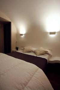 a bedroom with two beds and two lights on the wall at Pensión Iturriza in Donostia-San Sebastián