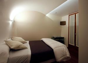 a bedroom with a bed with white pillows at Pensión Iturriza in Donostia-San Sebastián