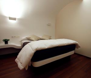 a bedroom with a bed with a white comforter at Pensión Iturriza in Donostia-San Sebastián